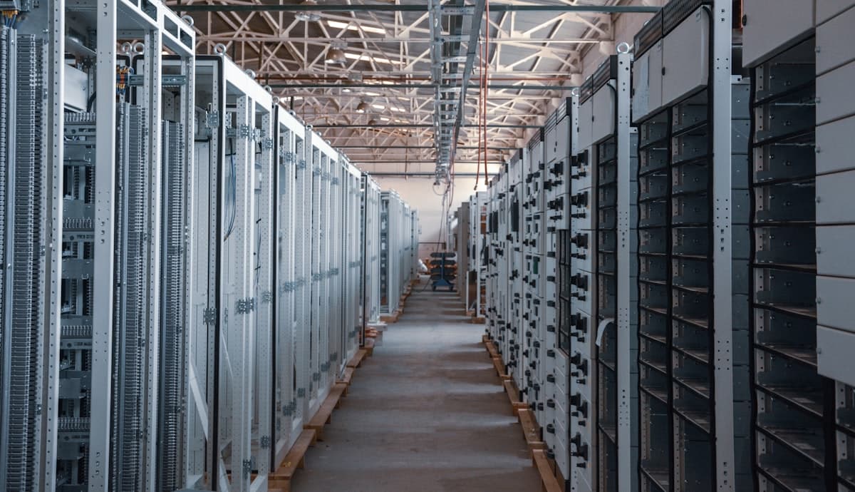 Corredor de data center com racks de servidores — infraestrutura por trás do investimento global em IA